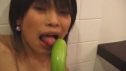 La jeune thailandaise Emma joue avec un concombre