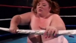 Une naine avec un gode ceinture baise une grosse femme sur un ring - Vidéo porno