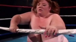 Une grosse femme baisée sur un ring par une naine avec un gode ceinture - Vidéo x